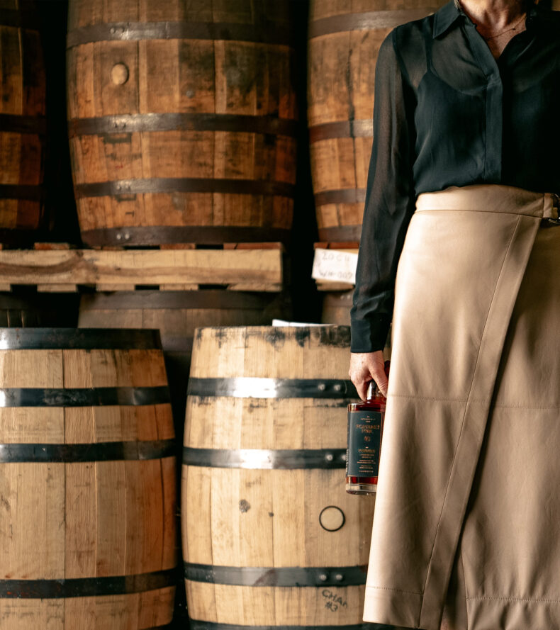 julie with barrels and bottle of Fortune's Fool : The Prelude